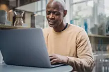 A bald man on his laptop.