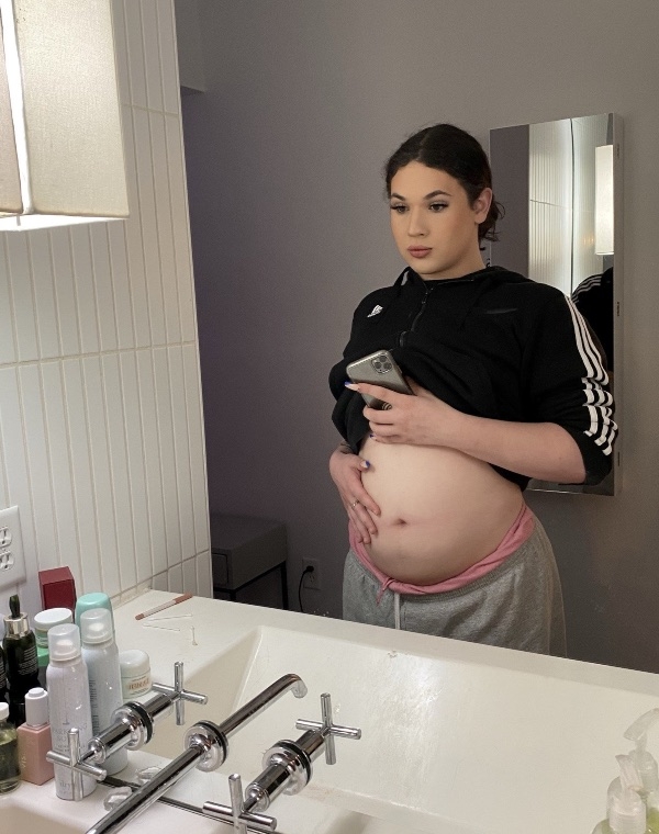 A woman holding her pregnancy bump.