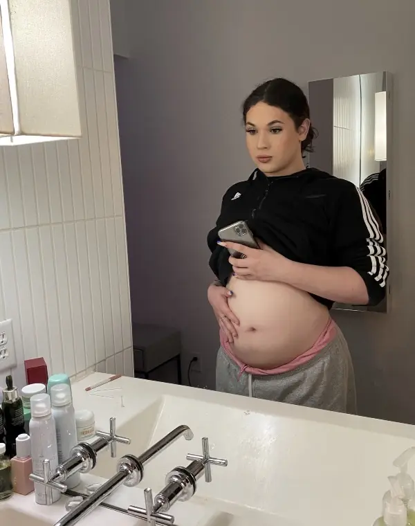 A woman holding her pregnancy bump. 