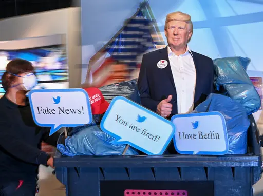 30 October 2020, Berlin: The wax figure of US President Donald Trump is pushed in a garbage container at Madame Tussauds Berlin. Under the motto 'Dump Trump', the figure, together with signs bearing sayings of Dream, will be symbolically 'disposed of' before the upcoming elections. Before the partial lockdown decided by the federal and state governments starting next Monday, the figure will be on display in the garbage container. Photo: Jens Kalaene/dpa-Zentralbild/dpa
