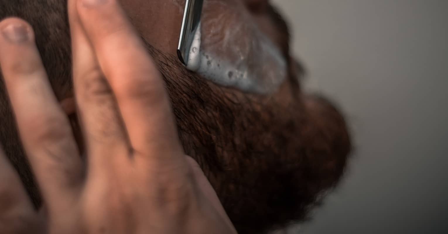 An image of someone shaving their facial hair.