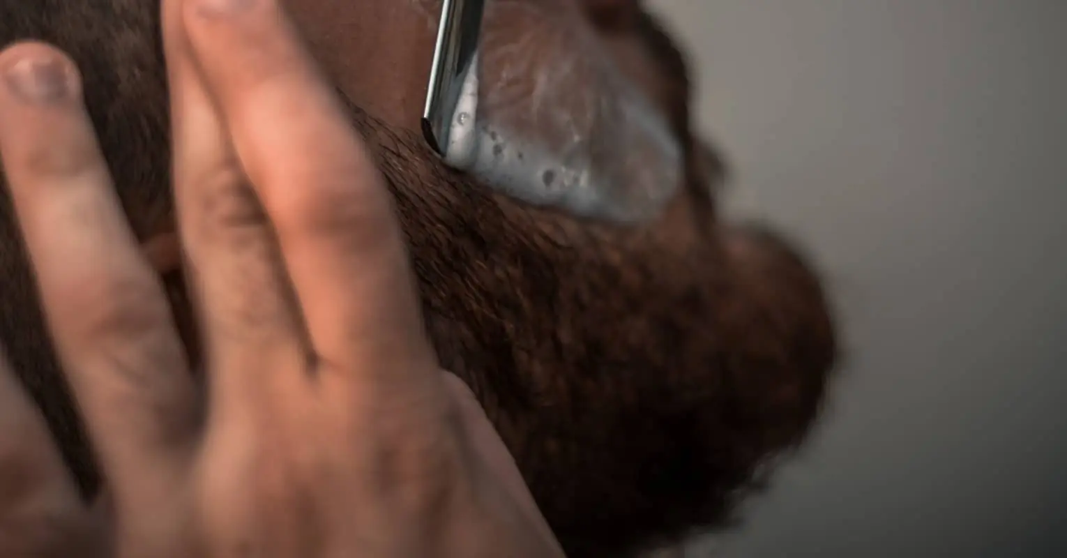 An image of someone shaving their facial hair.