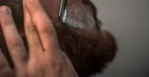 An image of someone shaving their facial hair.