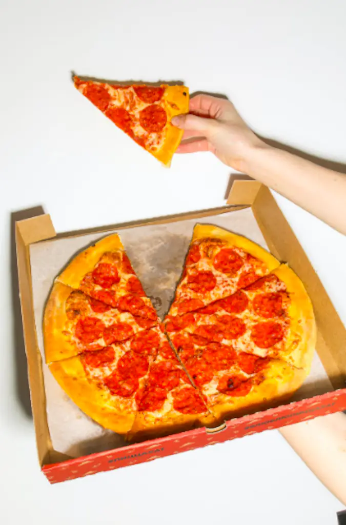A person holding a slice of pizza.