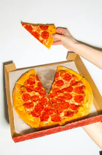 A person holding a slice of pizza.