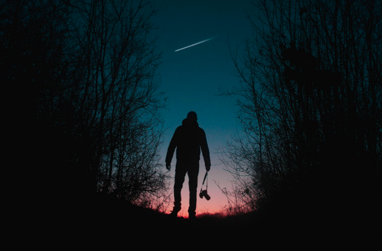 A man looking at a shooting star.