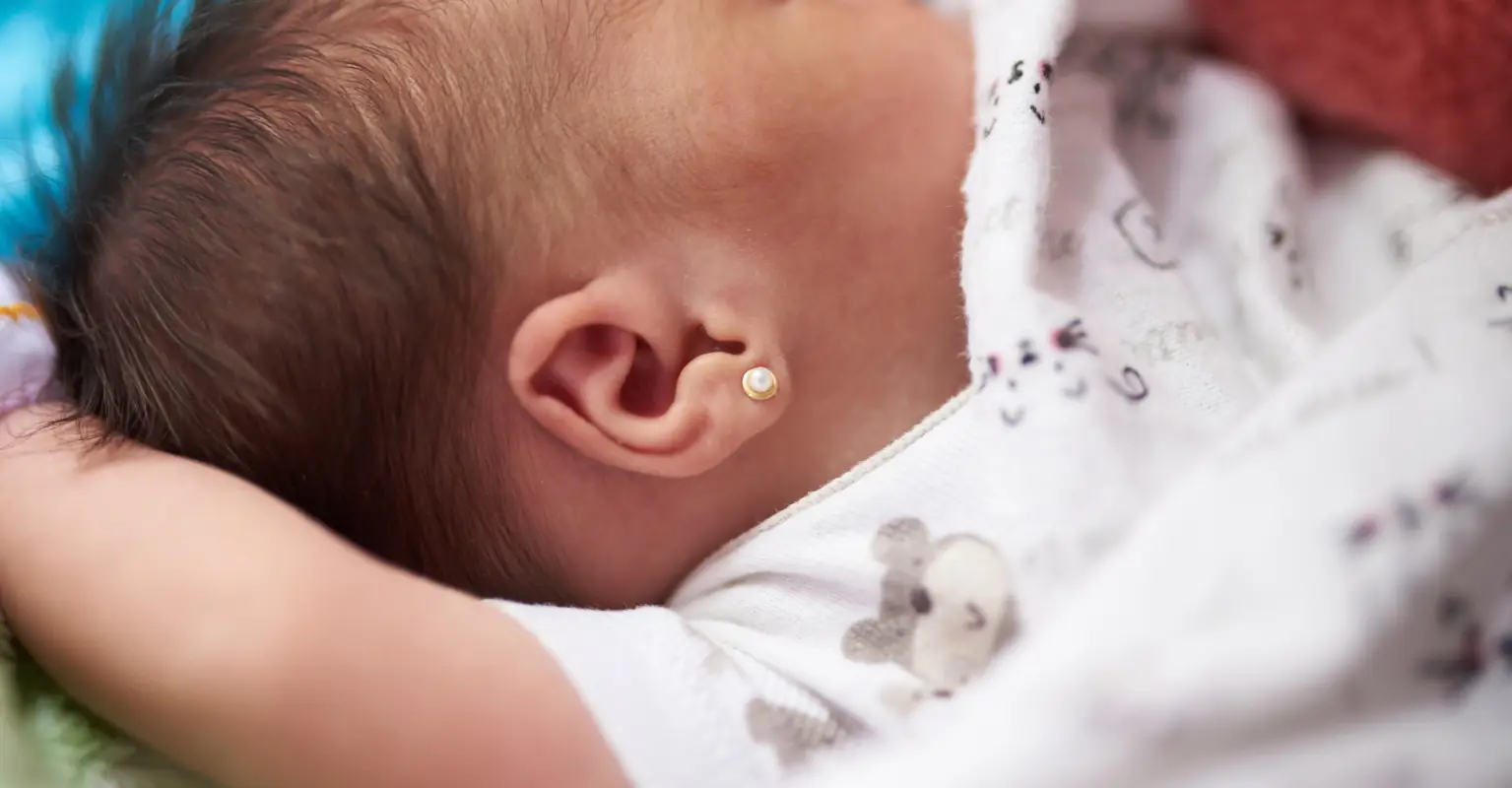 Mom sparks debate after piercing daughter's ears one day after she was born