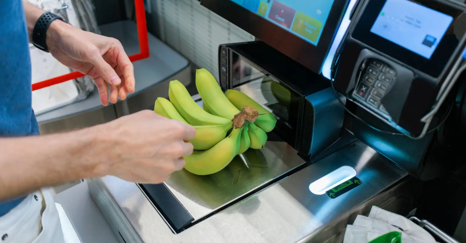 Man unwraps his bananas before weighing them at checkout to save money