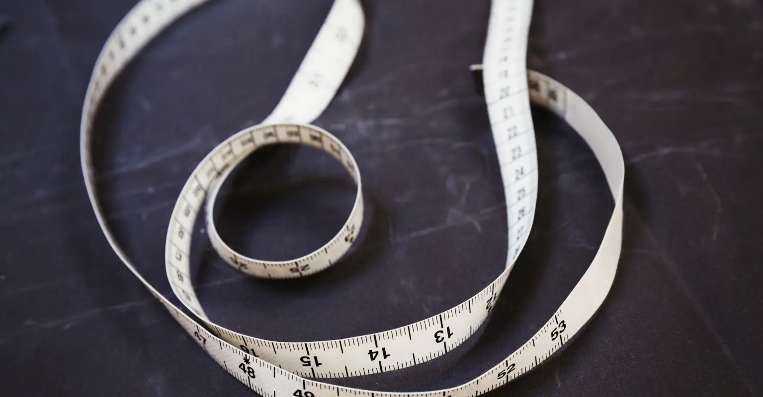 Woman pulls out measuring tape at bar to check man's height