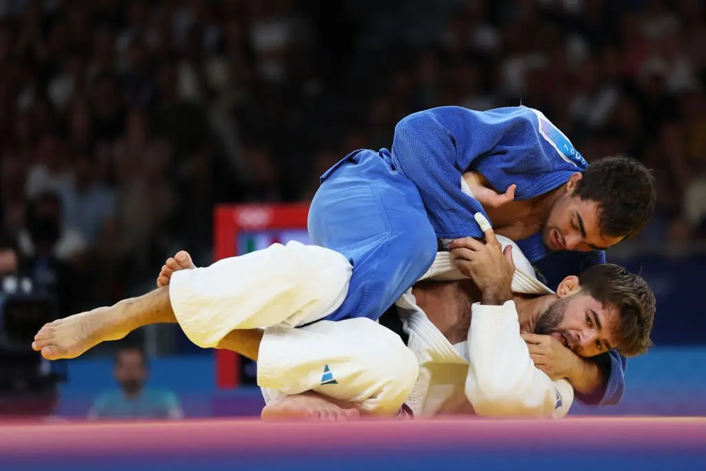 Adil Osmanov (Blue) of Team Republic of Moldova reacts against Manuel Lombardo (White) of Team Italy during the Judo Men's match. Credit: Alex Pantling/Getty