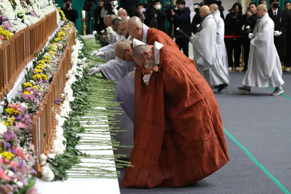 South Korean monks pay tribute at a group memorial altar for victims of Flight 7C2216. Credit: Chung Sung-Jun/Getty