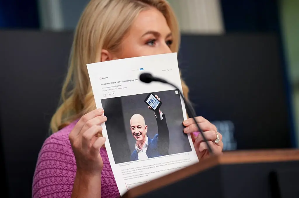 Leavitt held up a print out of a news article relating to Amazon and China. Credit:  Andrew Harnik/Getty Images
