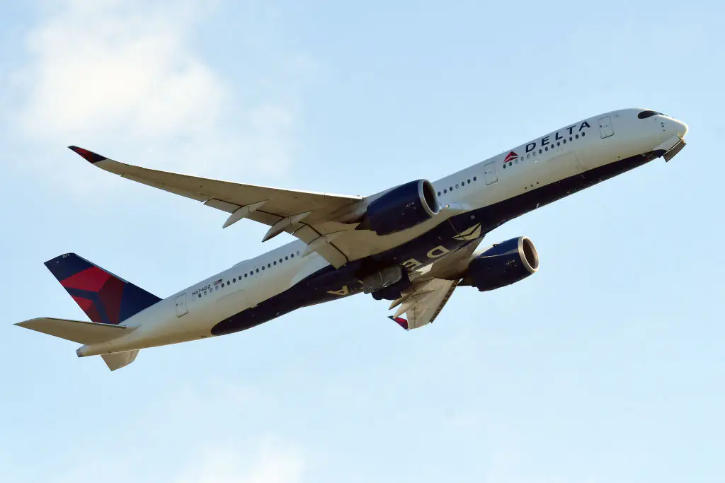 Flight attendant sits on the floor and holds nervous passenger's hand during flight