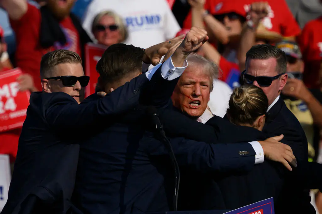 Donald Trump raising his fist after surviving an assassination attempt. Credit: Jeff Swensen / Getty
