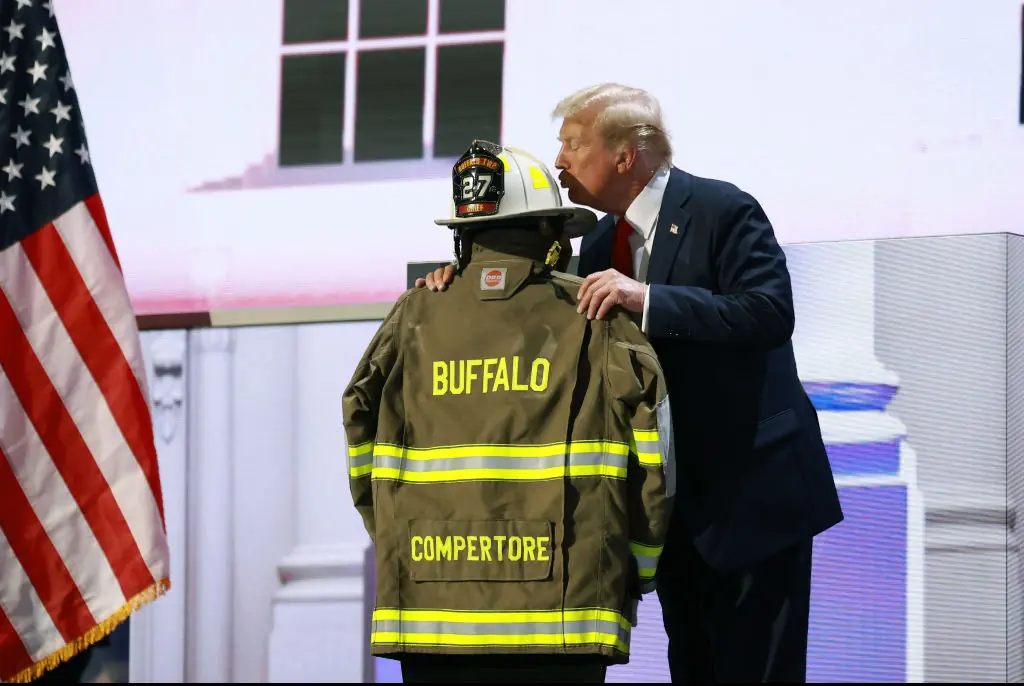 Trump kisses Comperatore's helmet. Credit: Joe Raedle/Getty 