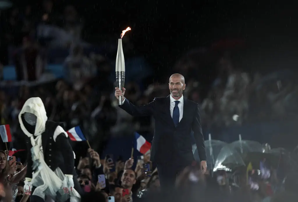 French former football player Zinedine Zidane carries the Olympic torch at the Trocadero during the opening ceremony of the Paris 2024 Olympics. Credit: Mustafa Ciftci/Anadolu/Getty