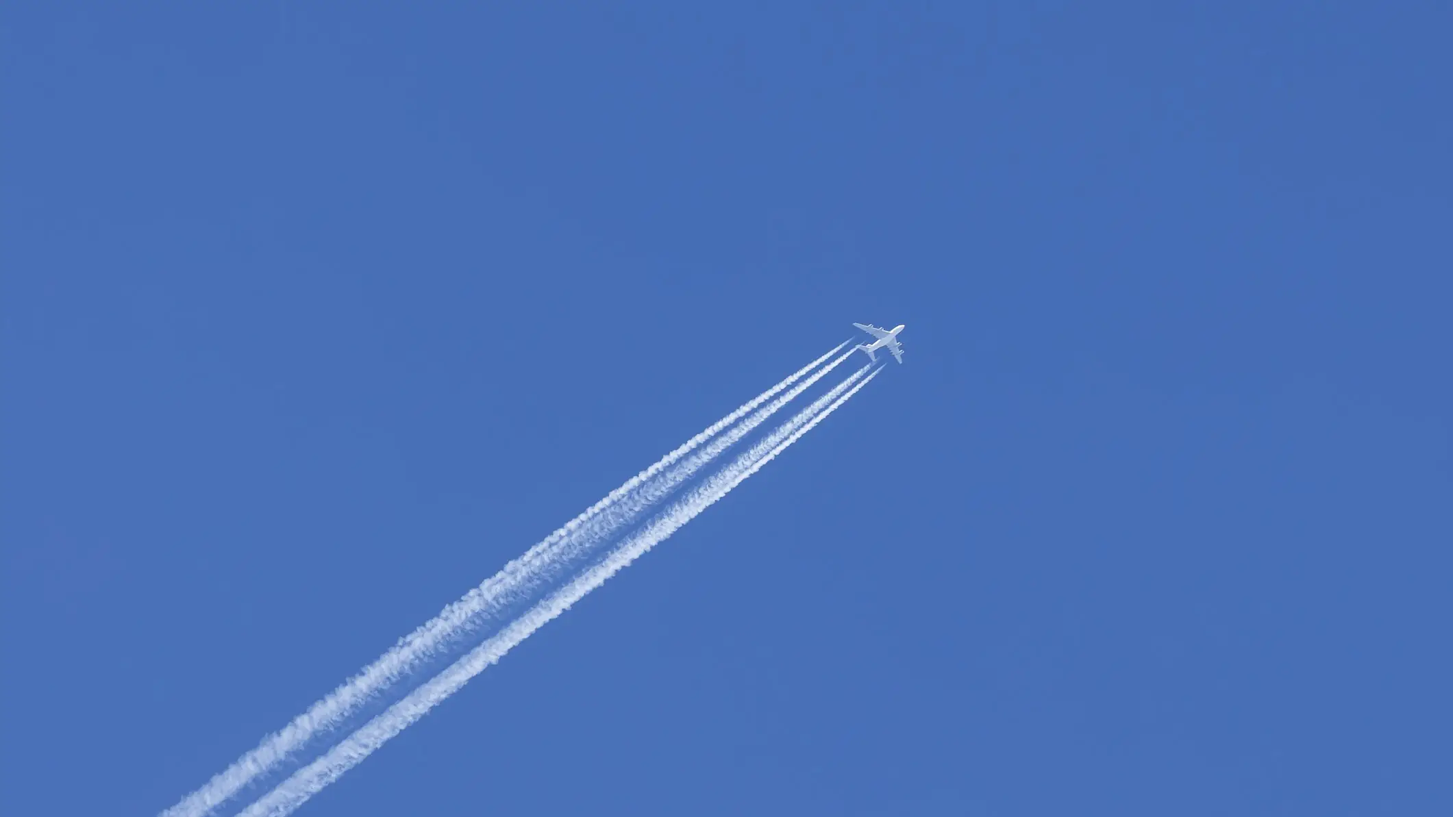 Aircraft in the blue sky with contrails - stock photo  Chemtrails