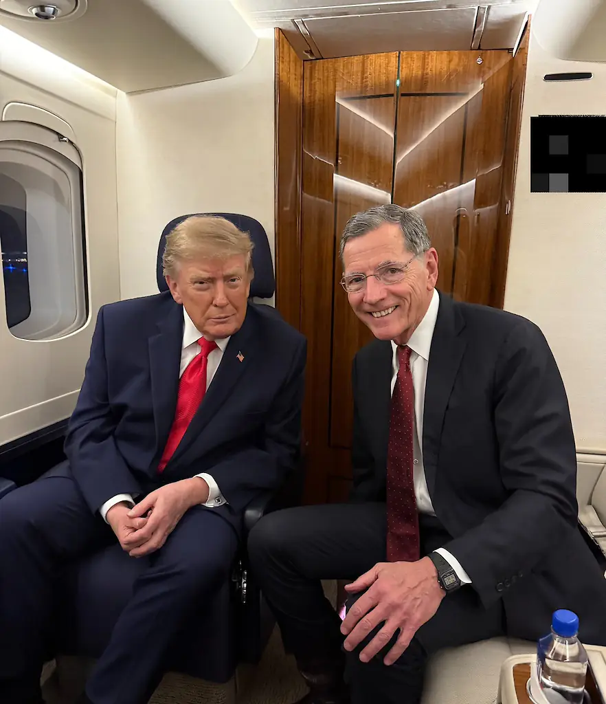 Donald Trump and Senator John Barrasso (with crew names blurred over his shoulder). Credit: X